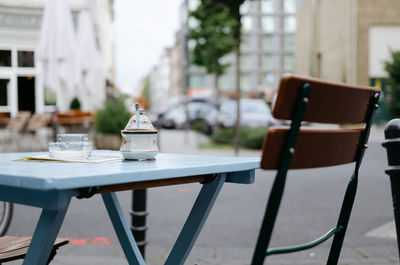 Empty chair and table at sidewalk cafe