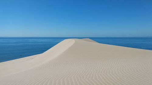 Scenic view of beach and sea against clear sky