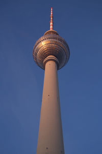 Low angle view of fernsehturm tower against blue sky