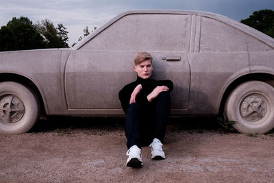 Portrait of teenage girl standing by car