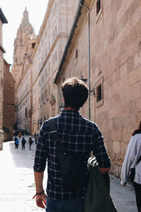 Rear view of young man walking on street