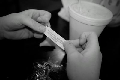 Cropped hand holding message on paper at restaurant