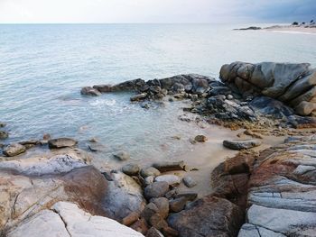 Rocks in sea against sky