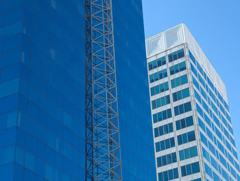 Low angle view of modern building against blue sky