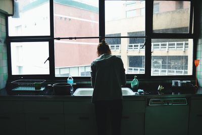 Rear view of woman in kitchen 