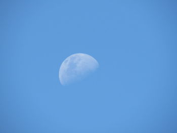 Low angle view of moon against blue sky at night