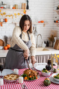 Portrait of young woman preparing food at home