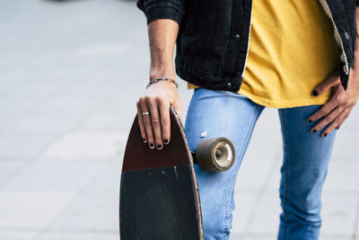 Low section of man holding hands standing outdoors