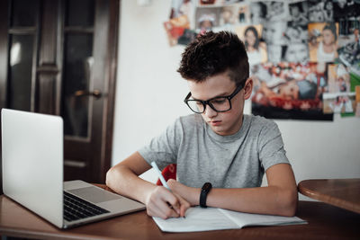 Man looking away while sitting on table