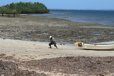 Man mooring boat at sea shore