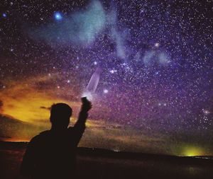 Silhouette man against sky at night