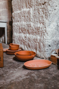 Close-up of bowl on table against wall