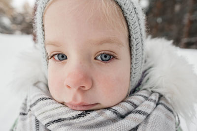 Little girl in warm clothes in a winter forest