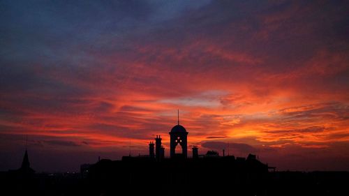 Silhouette buildings against sky at dusk