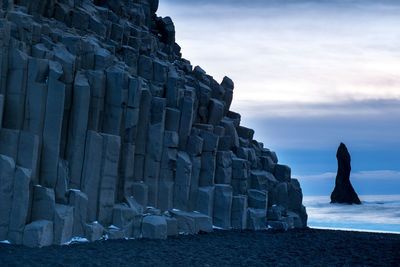 Low angle view of rocks on beach against sky