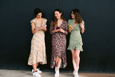 Full length of woman standing against wall