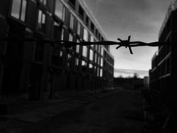 Close-up of airplane on fence against sky