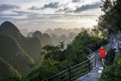 Man running on limestone mountains above yangshuo