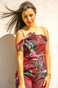 Portrait of beautiful woman standing against wall