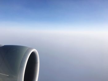 Close-up of airplane flying against clear blue sky