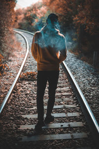 Rear view of man standing on railroad track