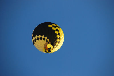 Low angle view of hot air balloon against clear blue sky