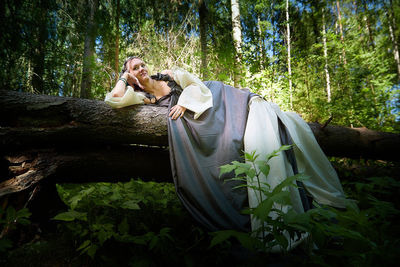 Side view of woman sitting on field