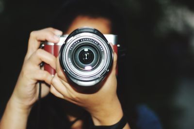 Close-up of photographer photographing by camera at night