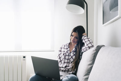 Full length of woman using mobile phone at home