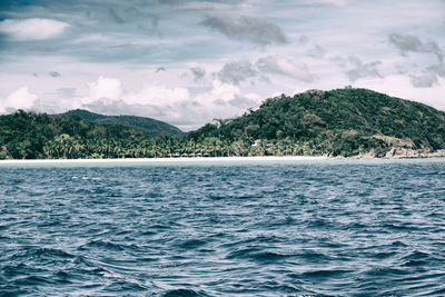 Scenic view of sea and mountains against sky