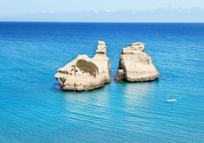 Panoramic view of rock formation in sea against sky