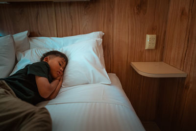 Low section of woman lying on bed at home