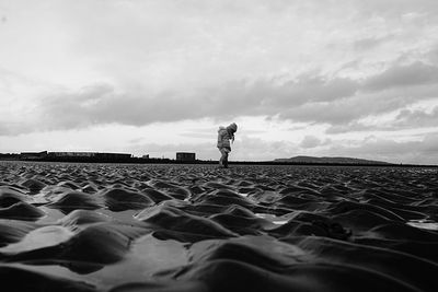 Surface level of girl at beach against sky