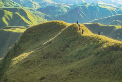 People on land against mountain range