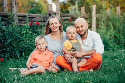 Portrait of family sitting on grass at park