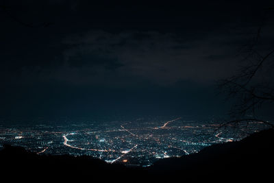 Illuminated cityscape against sky at night
