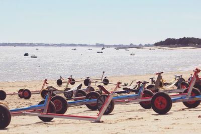 Vehicle trailers at beach against clear sky