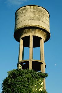 Low angle view of water tower against clear blue sky