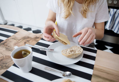 Midsection of woman holding food on table