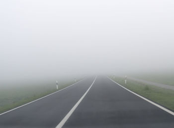 Empty road against sky during foggy weather