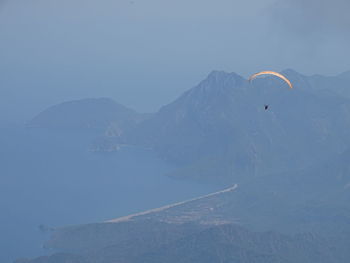 Person paragliding over sea