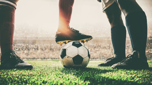 Low section of people relaxing on soccer field