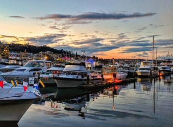 Boats moored at harbor during sunset