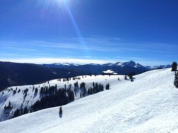 Scenic view of landscape against blue sky during winter