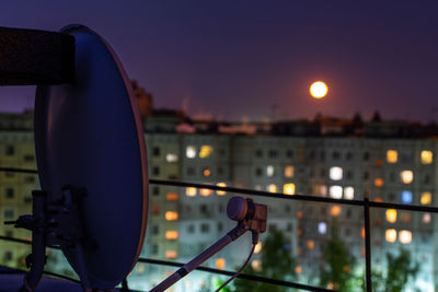 Close-up of illuminated lighting equipment against sky at dusk