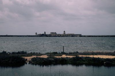 Scenic view of sea by buildings against sky