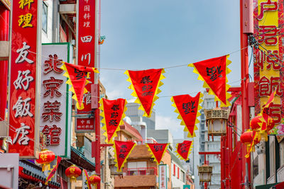 Low angle view of lanterns hanging amidst buildings in city