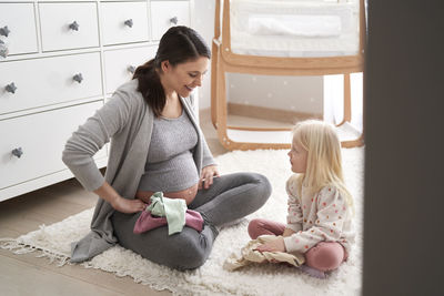 Pregnant woman with daughter at home