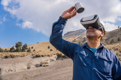 Man holding mug while wearing virtual reality headset