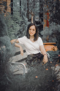 Portrait of young woman sitting on rock